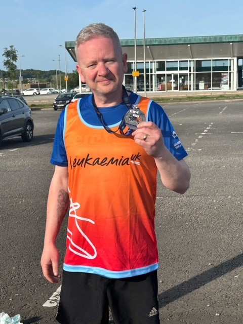 David shows off his medal after completing the marathon on May 28