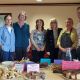 A group of people pictured with a table of edible goods