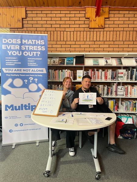 Maths support stall with male and female member of staff