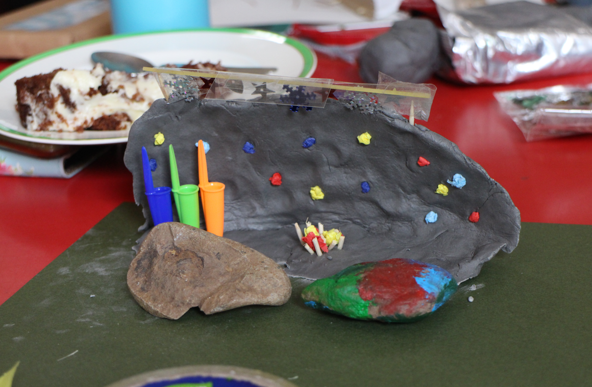 Clay model with colourful accents and piece of cake on table