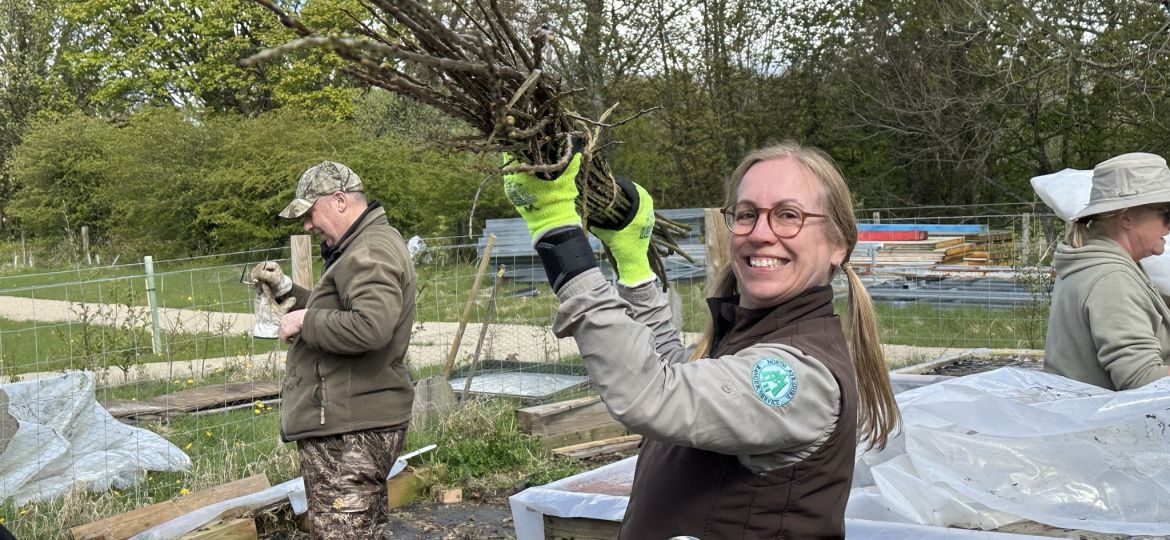 Countryside Ranger Sallie smiling as clearing branches at Eglinton Community Garden