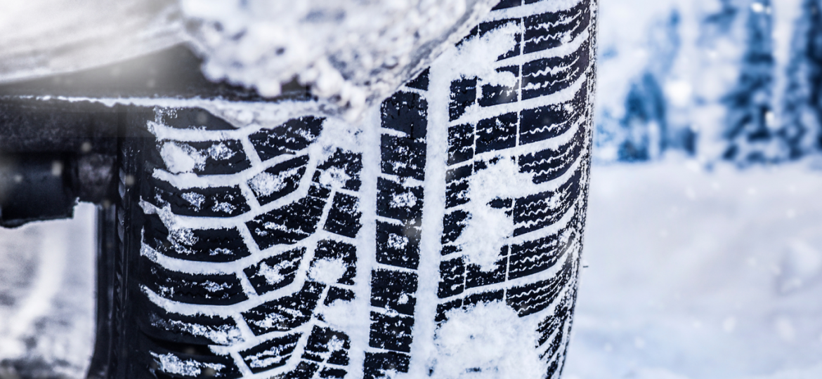 Car wheel on road covered in thick snow