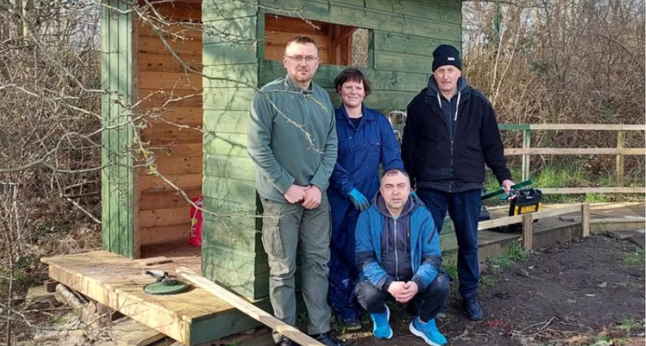 Group photo at nature hide - Ukrainian volunteer Yuriy, Locality Link Worker Lucy Russell and volunteers Taras and Mykola at the hide they created at Three Towns Growers in Ardrossan