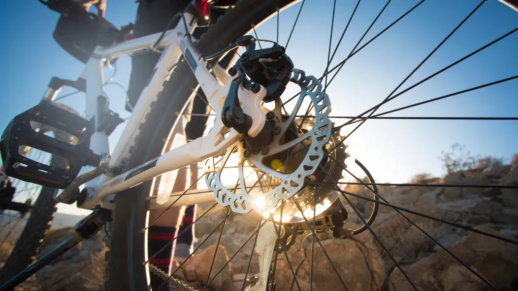 Close up of wheel of bike with sun shining through