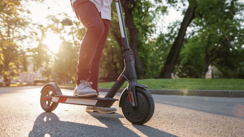 A person riding an e-scooter on a sunny day