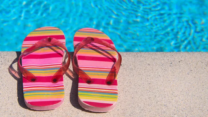 Flip flops next to swimming pool