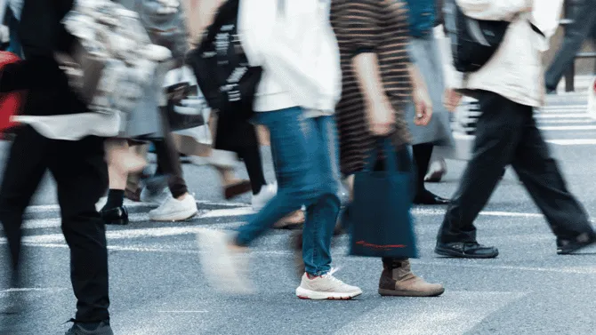 A view of a street with people crossing the road