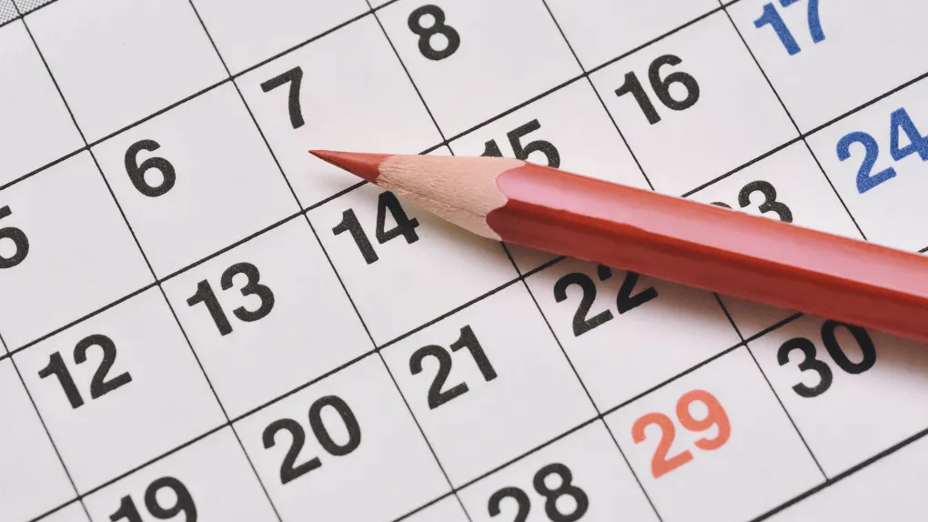 Calendar with red coloured pencil on top
